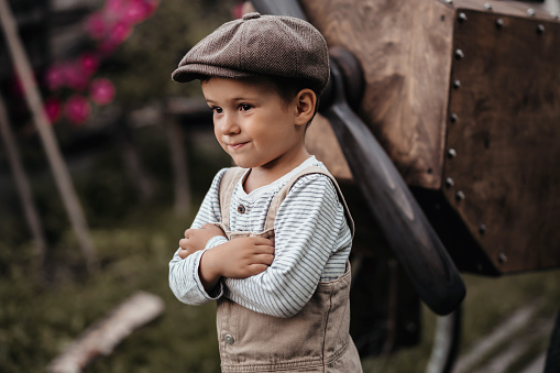 A young aviator boy near the propeller of a homemade airplane in a natural landscape. Close-up. Gives the picture an authentic mood. Vintage