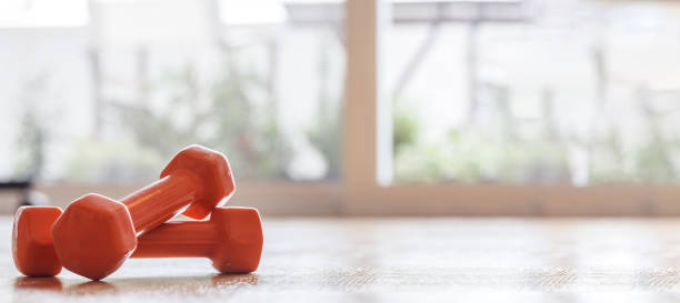 istock Pair of dumbbells on a wooden floor 1495545111