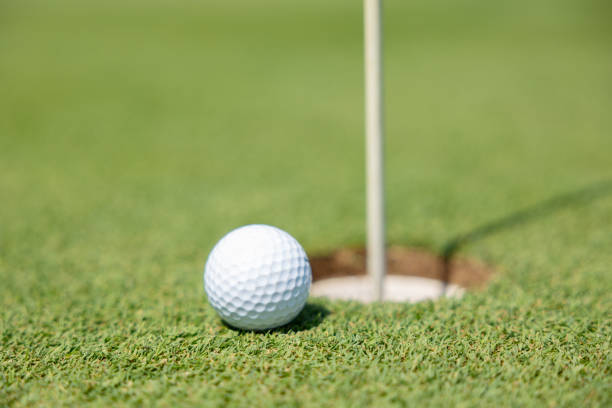 istock golf ball close to going into the hole cup with the flag still 1495551653