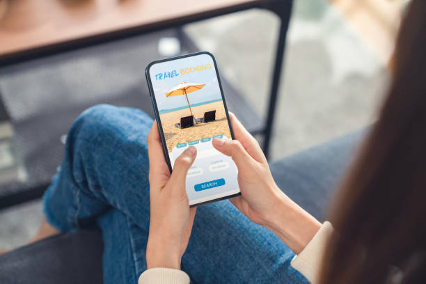 istock Hands holding smartphone with application booking flight travel search ticket holiday and hotel on website, concept technology online marketing and promotion. 1495552917