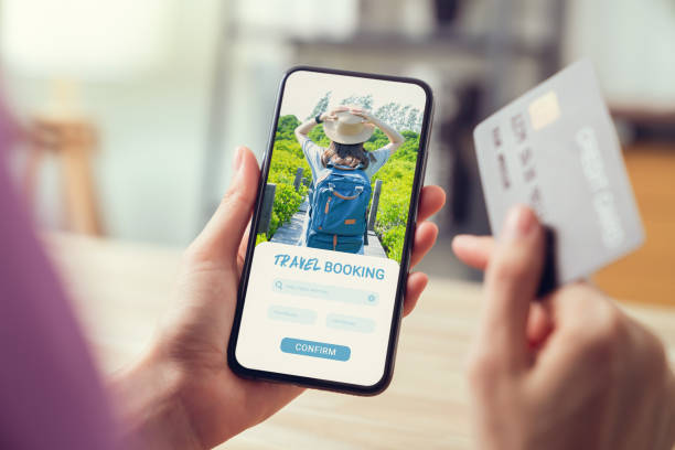 istock Hands holding smartphone with application booking flight travel search ticket holiday and hotel on website, concept technology online marketing and promotion. 1495553014