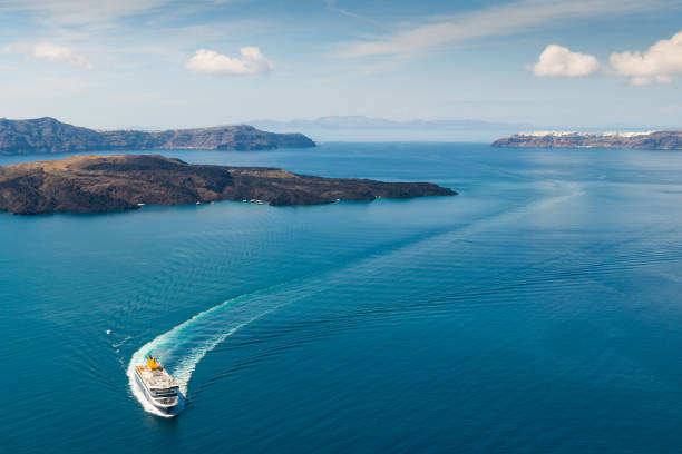 Ferry arrives at the port of Santorini Island, Greece. Blue sea and the blue sky with clouds. stock photo