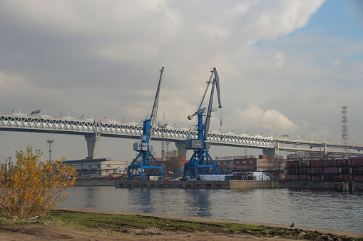 Photo of the Kanonersky Island in autumn, St. Petersburg, view of the port cranes, port constructions and overpass of the Western Expressway Diameter