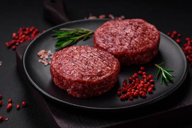 istock Fresh raw ground beef burger patty with salt and spices 1495561528