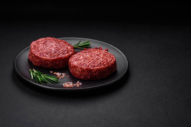 istock Fresh raw ground beef burger patty with salt and spices 1495561894