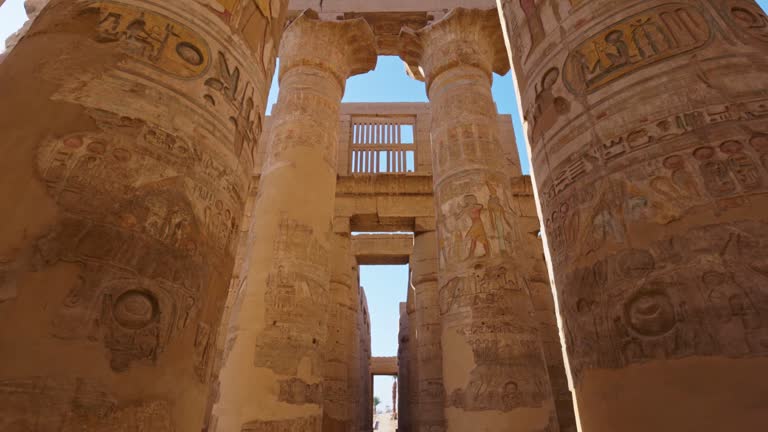 Karnak Temple in Luxor, Egypt. Camera moves between majestic columns with ancient Egyptian drawings.  Gimbal high quality shot