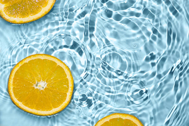 istock Creative summer background with orange fruit slices in swimming pool water. 1495565083