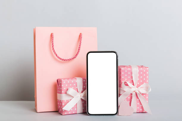 istock mobile phone with blank screen on colored background with hearts, calendar and gift box, valentine day concept perspertive view flat lay 1495565224