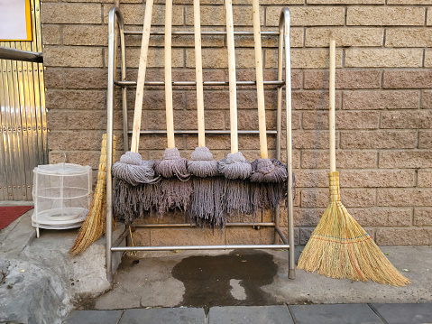 Brooms,mops,brush,bucket against white wall