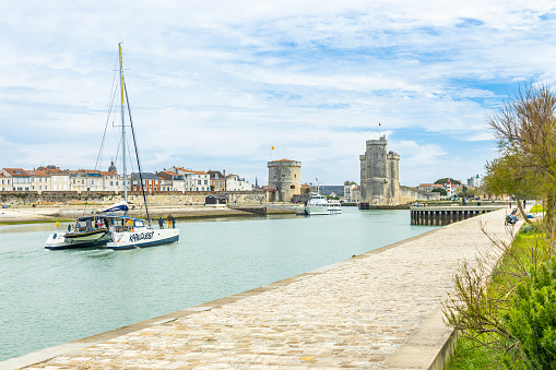 The two towers and catamaran sailing at the entrance of the Old Port of La Rochelle, France