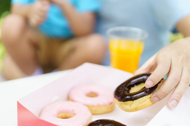 istock Happy father and son eating doughnut together. 1495570916