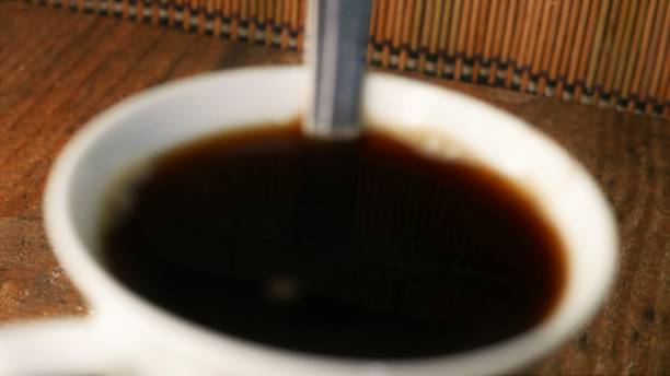 eine unkonzentrierte tasse kaffee. ein löffel in einer kaffeetasse. kaffeetasse auf dem tisch. kaffeepause. zeit für schwarzen kaffee. kaffee trinken. couchtisch seitenwinkel - snack coffee instant coffee cappuccino stock-fotos und bilder