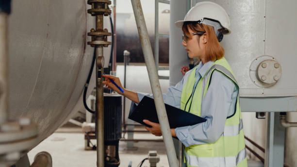 Young Asian female industrial engineer in hard hats checking steam boiler in chemical manufacturing factory. Heavy Industry and engineers. Young Asian female industrial engineer in hard hats checking steam boiler in chemical manufacturing factory. Heavy Industry and engineers concept. Master’s Degree in Petroleum Engineering stock pictures, royalty-free photos & images
