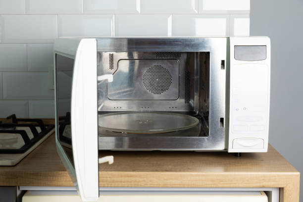 istock Modern white microwave on the kitchen countertop.Using microwave everyday in the kitchen. The concept of cooking. 1495579229