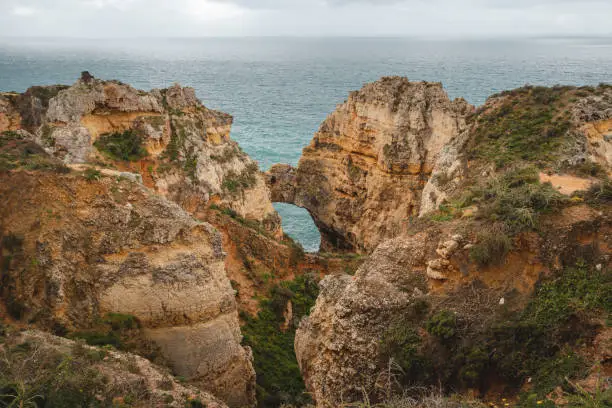 Famous tourist destination of Ponta da Piedade on the southern peninsula of Lagos in the Algarve region of Portugal. Cape of yellow-gold cliffs during the afternoon.