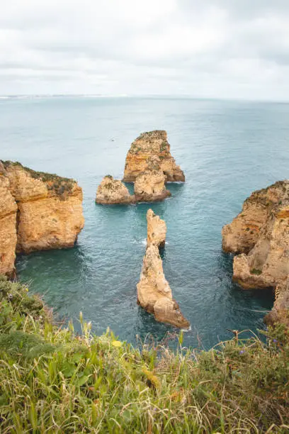 Famous tourist destination of Ponta da Piedade on the southern peninsula of Lagos in the Algarve region of Portugal. Cape of yellow-gold cliffs during the afternoon.