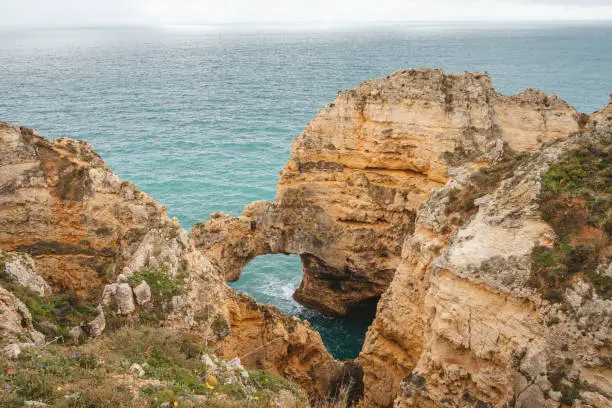 Famous tourist destination of Ponta da Piedade on the southern peninsula of Lagos in the Algarve region of Portugal. Cape of yellow-gold cliffs during the afternoon.