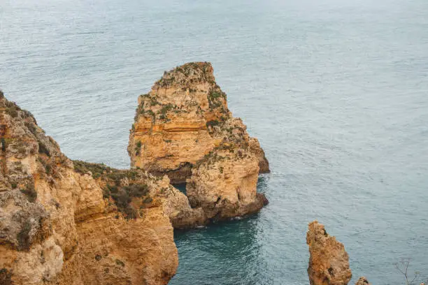 Famous tourist destination of Ponta da Piedade on the southern peninsula of Lagos in the Algarve region of Portugal. Cape of yellow-gold cliffs during the afternoon.