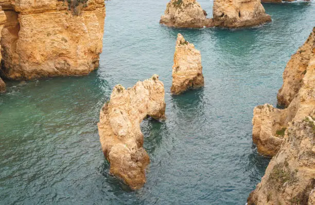 Famous tourist destination of Ponta da Piedade on the southern peninsula of Lagos in the Algarve region of Portugal. Cape of yellow-gold cliffs during the afternoon.