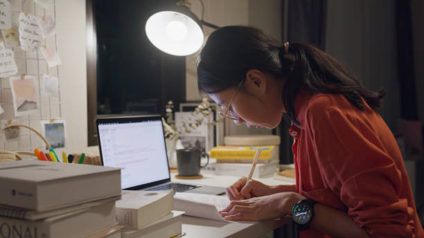 istock Young Asian woman wear casual sit front of desk with computer laptop and think create on work idea in living room at house at night. Work from home. 1495581945