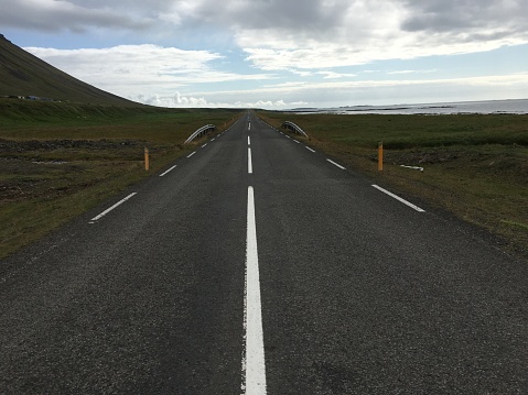 Empty road trough Iceland near the sea on a beautiful sunny autumn day.