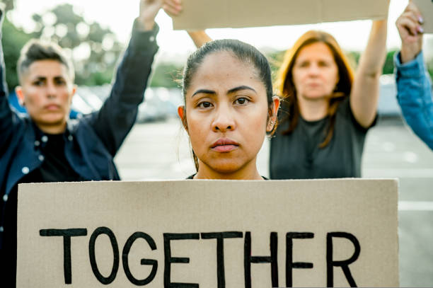 istock Serious woman in group of others with protesting cardboard 1495582947