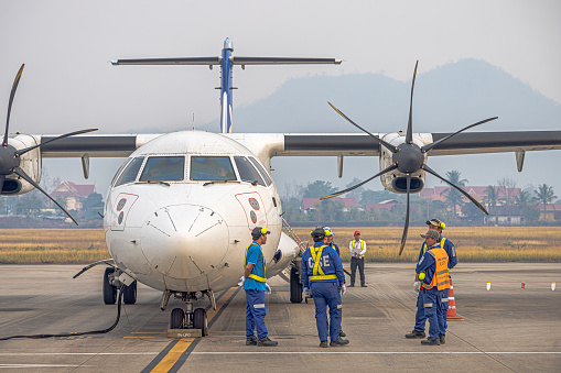 A commercial jet belonging to South Africa's Airlink Airline at Hosea Kutako International Airport of Windhoek in Khomas Region, Namibia. A person is visible in the background.