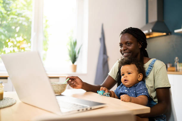 istock Mother feeding her baby boy while having a video call over laptop 1495585512
