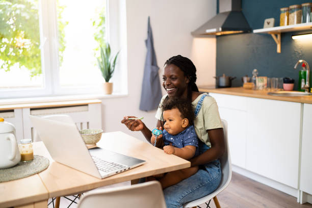 istock Mother feeding her baby boy while having a video call over laptop 1495585533
