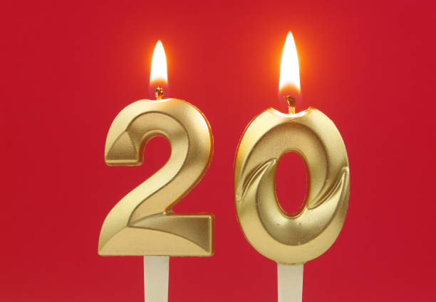istock Gold birthday candles burning on red. Number 20 1495586019