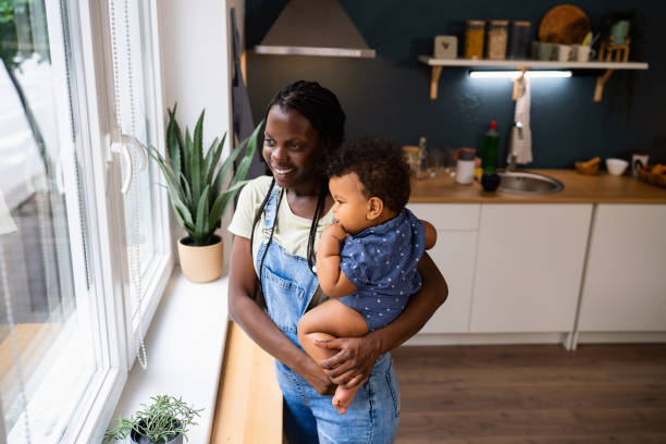 istock Mother and baby son looking through window from their home 1495586082