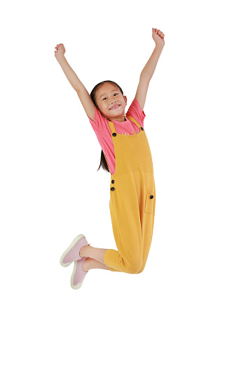 Asian little girl child jumping and freedom movement on air isolated over white background. Happy kid with smiling shot. Full length