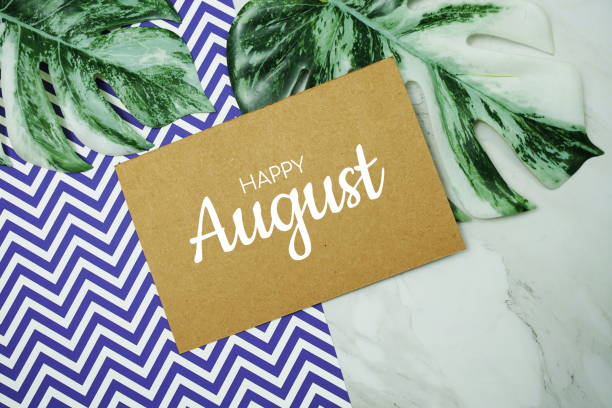 istock Hello August typography text on paper card with Monstera leaves on marble background 1495589453