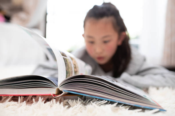 istock girl reading a book at home 1495601022