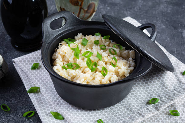 istock Stewed rice with chicken in a pot on dark grey background 1495601611