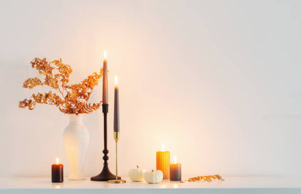 istock beautiful autumn home decor with burning candles in white interior 1495602469