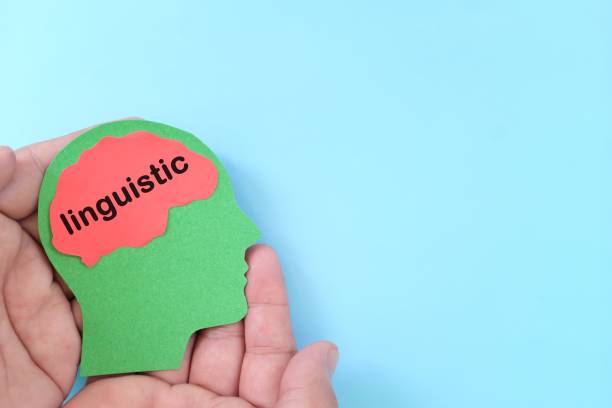 istock Linguistic intelligence in psychology concept. Hand holding human head profile with word text on brain. 1495603218