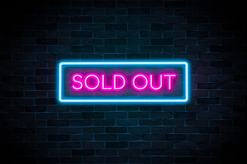 Sold out neon banner on brick wall background.