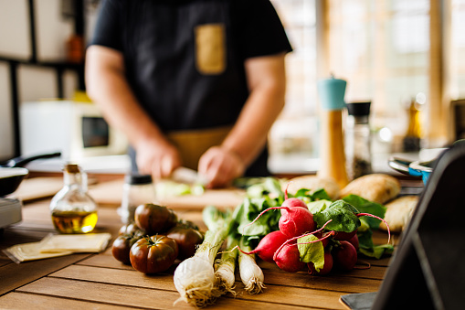 Overweight man cutting fresh vegetables