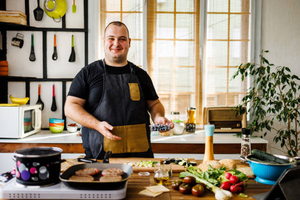 istock Smiling overweight man have fun during cooking at home 1495603729