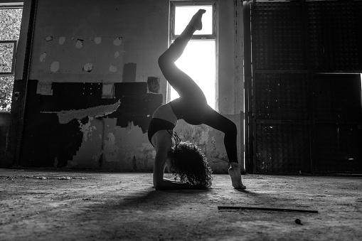 Young beautiful woman in black sportswear doing yoga practice.