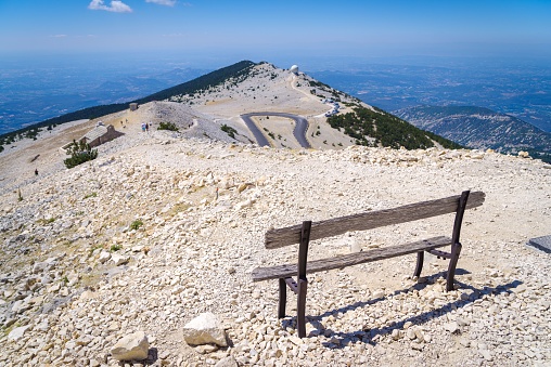 A bench in a scenic spot with a view of the mountains and blue sky. Mont Ventoux, France.