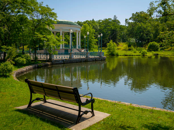Tranquil lake landscape with a bench,  water reflections, and a Pavillion