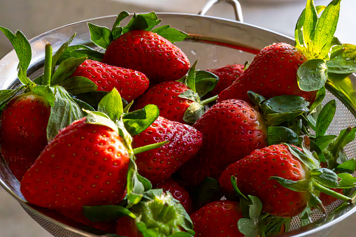 Ripe Strawberries in a colander washed and prepared for eating.