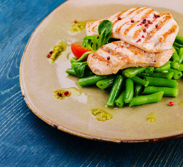 istock Grilled chicken fillets on green beans 1495611893