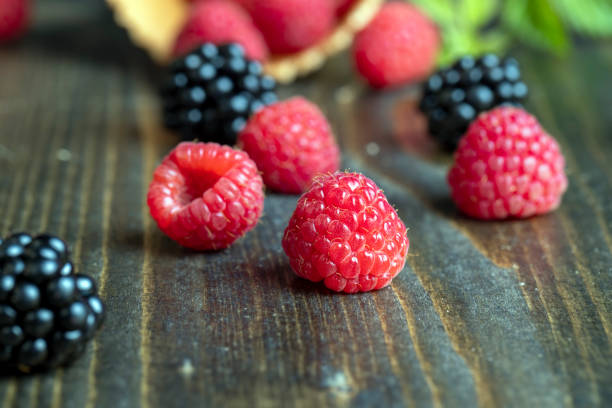 Ripe raspberries and wild blackberries on a vintage plate