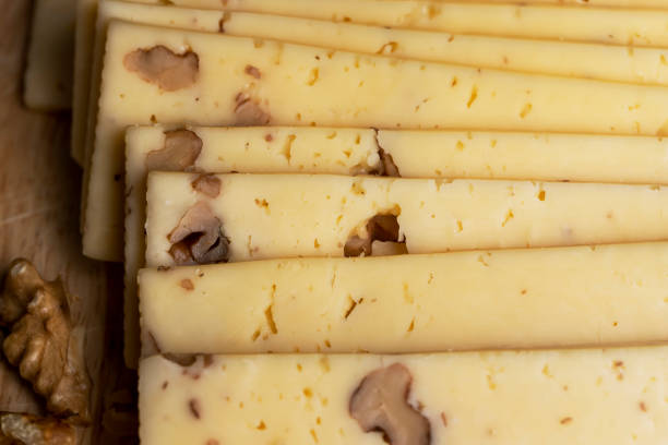 istock Sliced piece of milk cheese with walnuts 1495623003