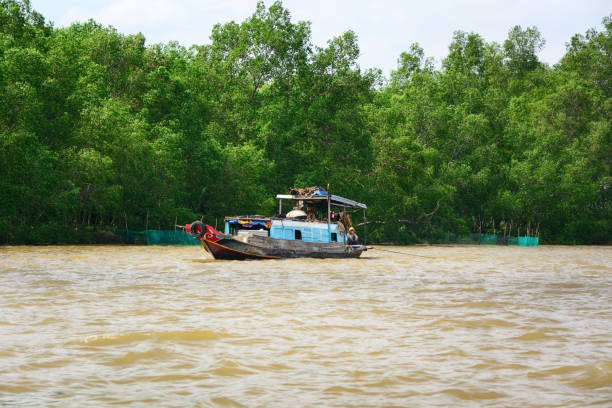 barge carrying bags of fertilizer moving along the Mekong River, in Vietnam, with laundry hanging to dry in the cabin
