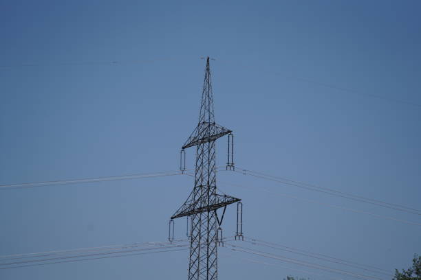 High voltage power line on blue sky background. Electricity distribution station.