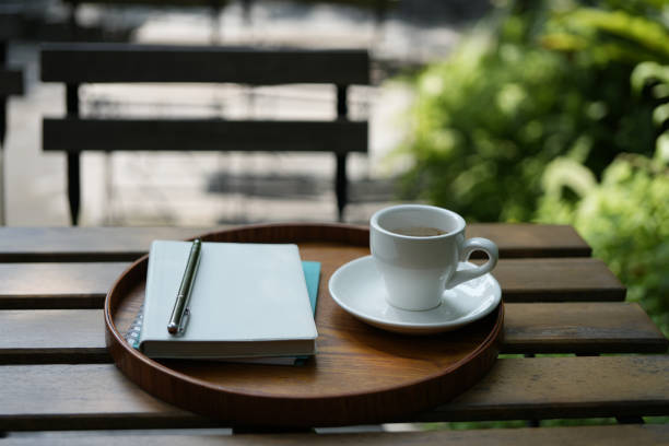 istock White coffee cup on wooden table with notebooks on wooden tray 1495632526